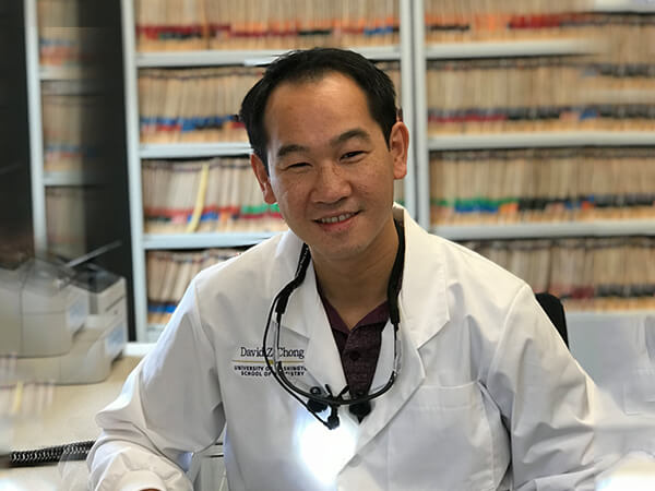 One of our dentists, Dr. Chong sitting at his desk